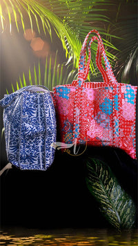 Two patterned bags, one blue and white, one red and blue, against a dark background with leafy greenery.