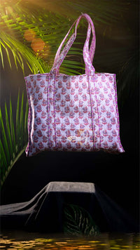 Floral patterned tote bag on a dark background with green leaves