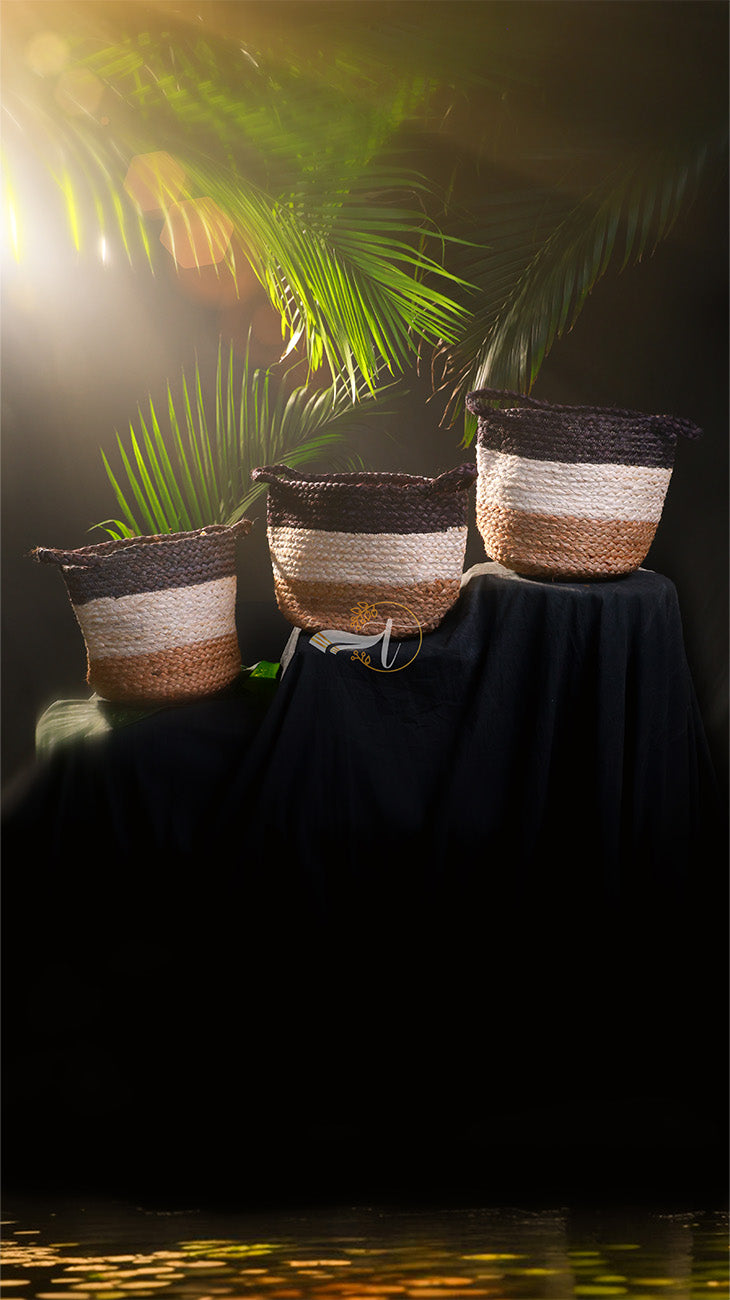 Three woven baskets on a dark surface with a blurred natural background