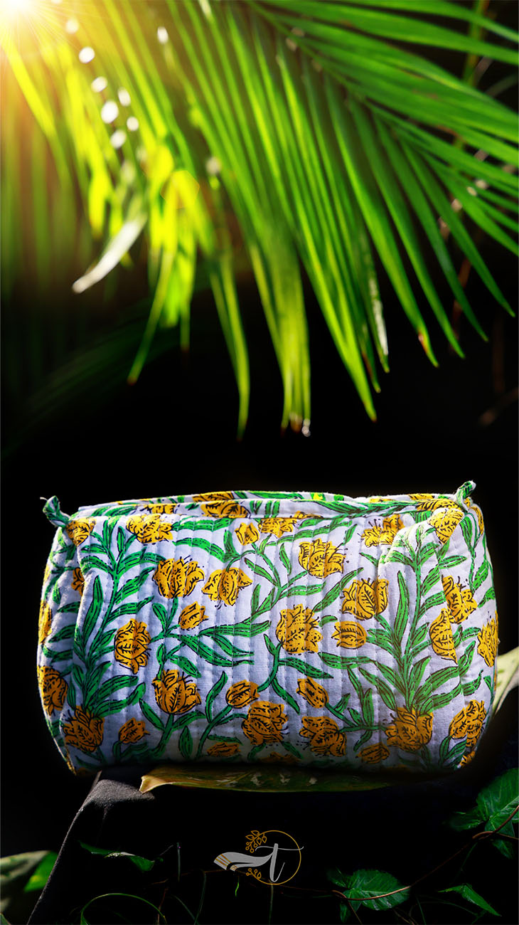 Embroidered pouch with floral pattern against a green leafy background