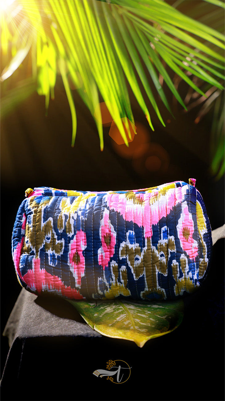 Colorful patterned pouch on a dark background with green leaves