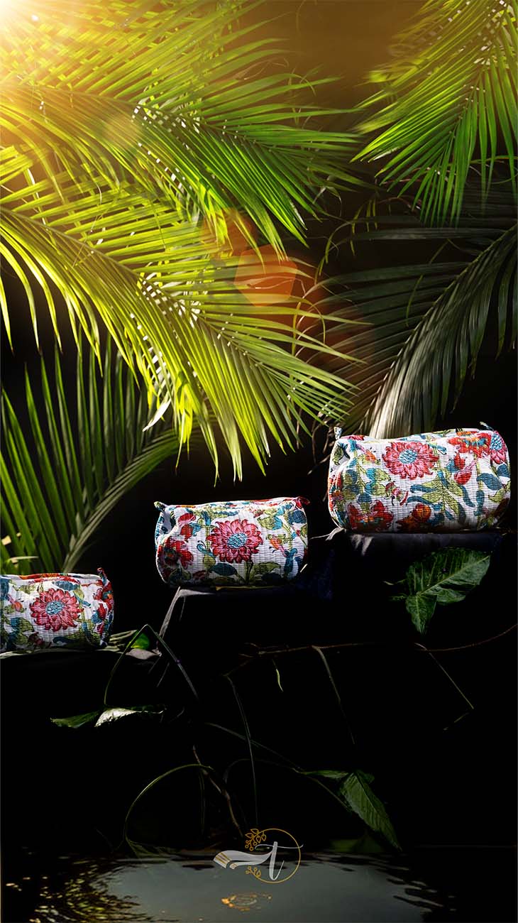 Floral-patterned bags on a dark background with green foliage