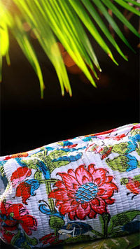 Colorful floral-patterned fabric with a palm leaf in the background