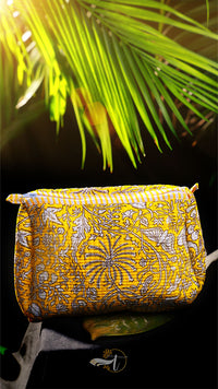 Yellow patterned bag with palm leaves in the background