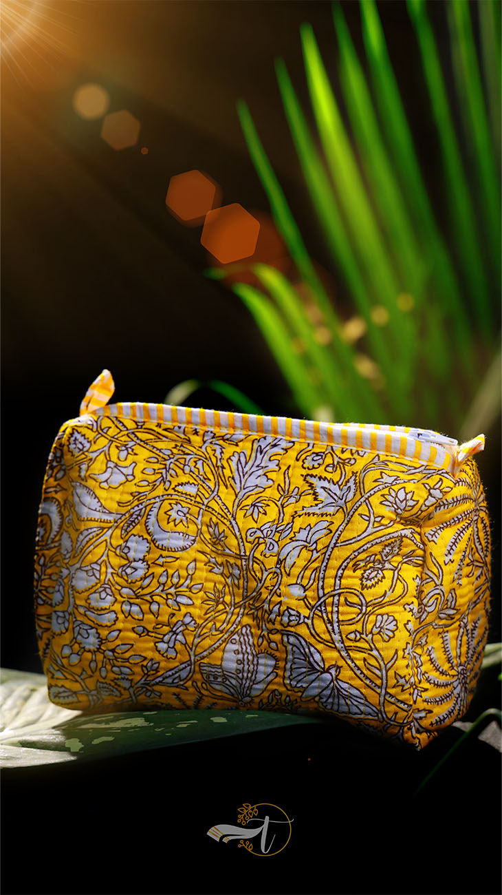 Yellow patterned pouch with a plant in the background