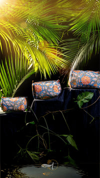 Decorative bags with floral patterns on a dark surface with palm leaves in the background