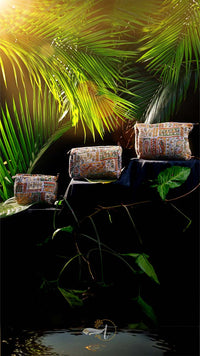 Decorative pillows on a stone ledge with green foliage in the background