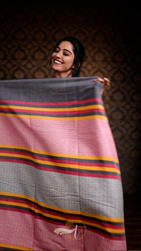 Woman holding a large fabric with colorful stripes against a dark background