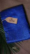 Blue fabric with a 'THANVI' tag on a brown surface