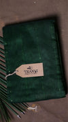 Green fabric with a Thanvi tag on a dark background