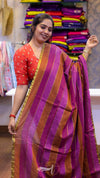 Woman wearing a red and purple saree with a colorful background