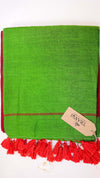 Green towel with red tassels and a visible brand tag on a white background