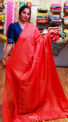 Woman wearing a red saree with a blue blouse in a store setting.
