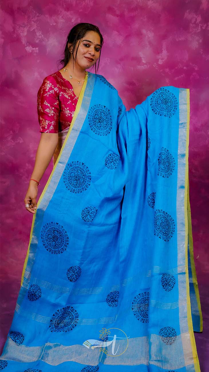 Woman wearing a blue saree with a pink background