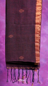 Dark brown scarf with gold border and tassels on a purple background