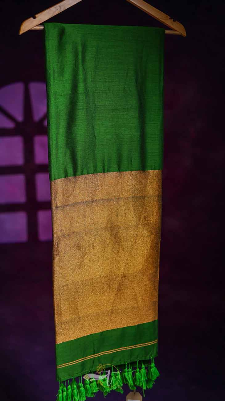 Green and brown scarf with tassels on a dark background