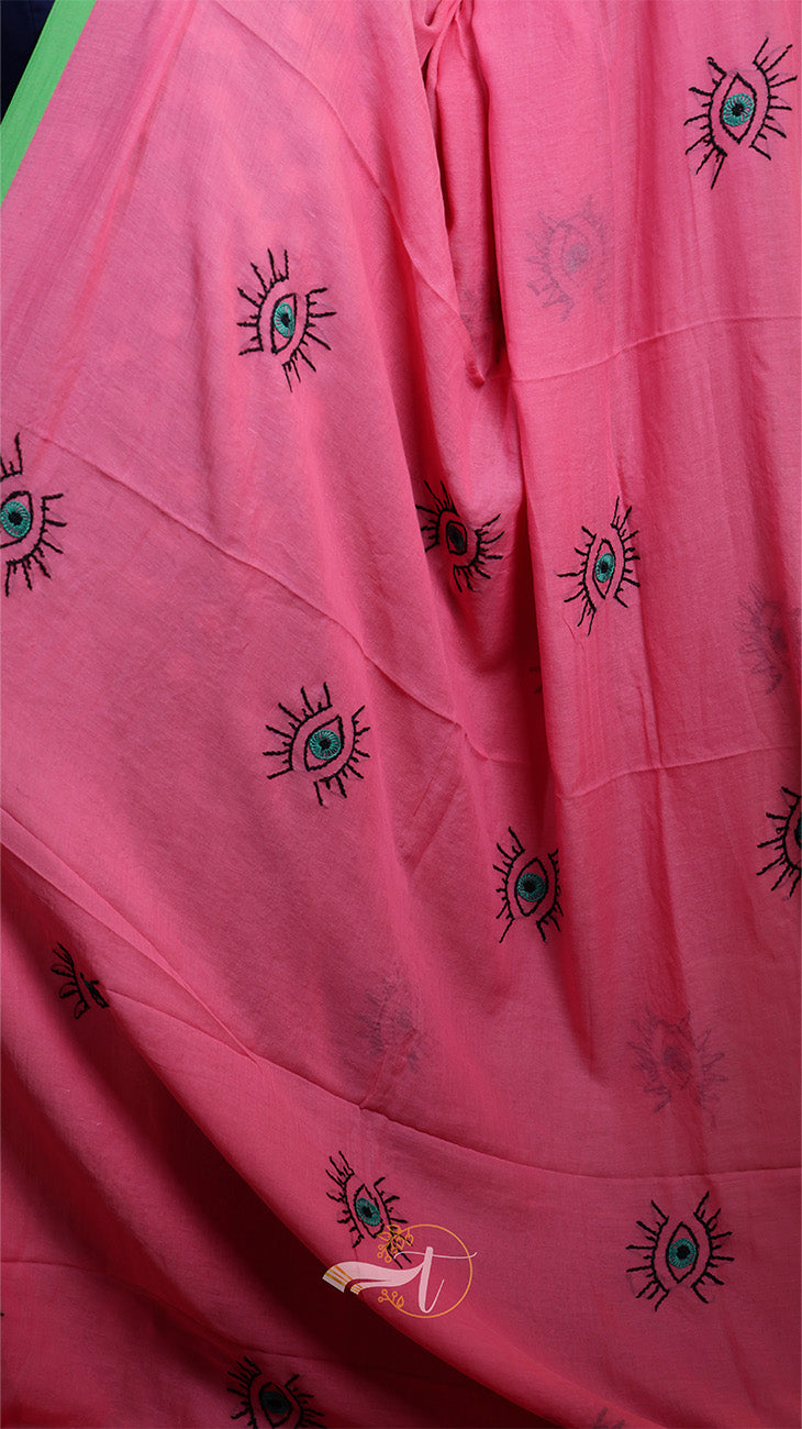 Pink fabric with black embroidered designs on a pink background