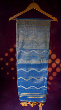 Blue and white patterned fabric on a hanger against a dark background with orange circular lights.