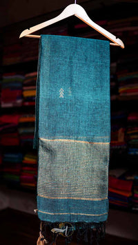 Blue fabric on a hanger with a blurred background of shelves.