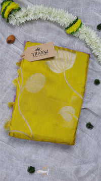 Yellow fabric with floral patterns on a gray surface with decorative elements.