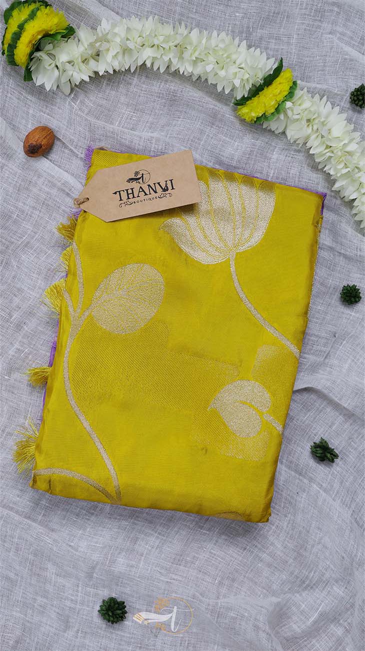 Yellow fabric with floral patterns on a gray surface with decorative elements.