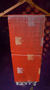 Red fabric with gold floral patterns on a hanger against a dark background