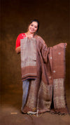 Woman holding a brown and beige patterned fabric against a brown background