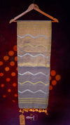 Textile with wavy patterns on a hanger against a dark background