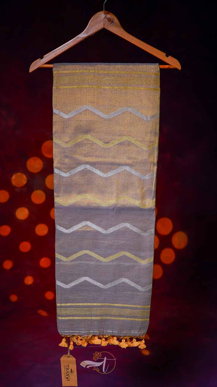 Textile with wavy patterns on a hanger against a dark background
