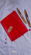 Red fabric with tassels and a tag on a light gray background