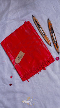 Red fabric with tassels and a tag on a light gray background