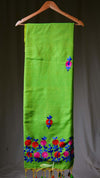 Green scarf with floral embroidery on a hanger against a gray background