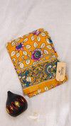 Colorful fabric with floral patterns and a black decorative item on a light gray background
