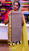 Woman holding a brown fabric with decorative elements in a colorful fabric store.