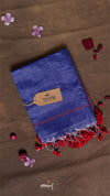 Blue towel with red tassels on a brown surface with flowers