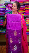 Woman holding a purple saree with a colorful fabric background