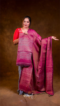 Woman wearing a pink saree with a red blouse against a brown background