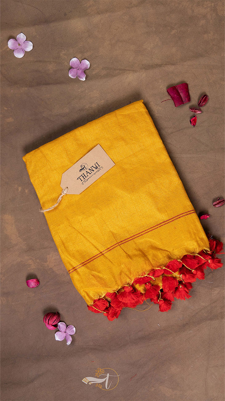Yellow saree with red and pink flower petals on a brown background