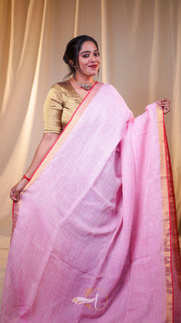 Woman wearing a pink saree with a gold blouse against a beige curtain background