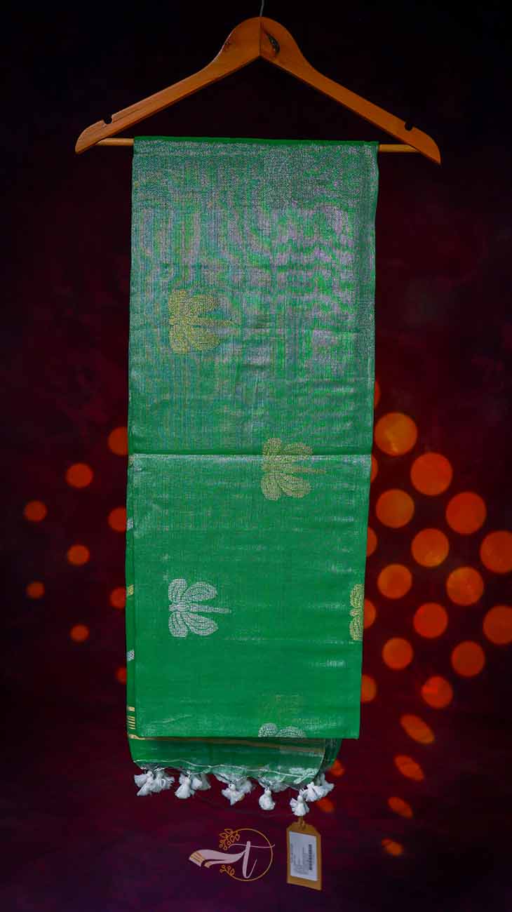 Green fabric with white patterns on a hanger against a dark background