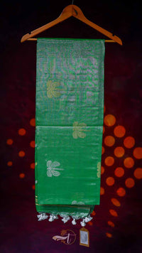 Green fabric with white patterns on a hanger against a dark background
