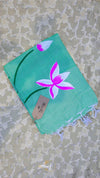 Turquoise scarf with pink flower design on a textured surface