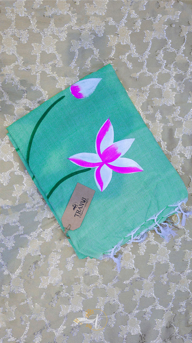 Turquoise scarf with pink flower design on a textured surface