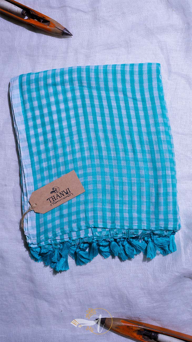 Turquoise checkered towel with tassels on a light gray background
