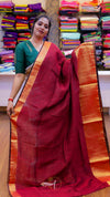 Woman holding a red and orange saree in a fabric store
