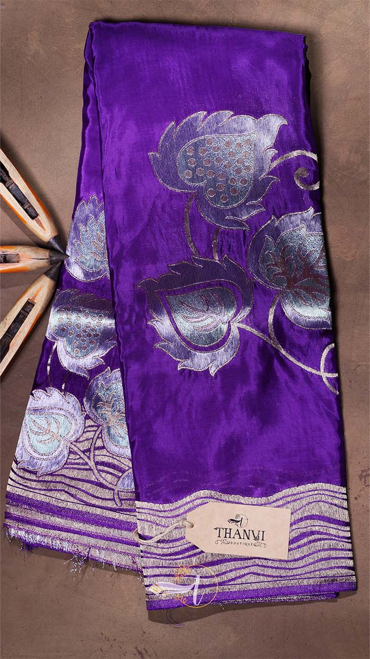 Purple scarf with silver floral patterns on a brown background
