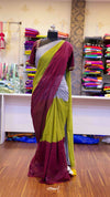 Saree on a mannequin in a store setting with colorful fabrics in the background.