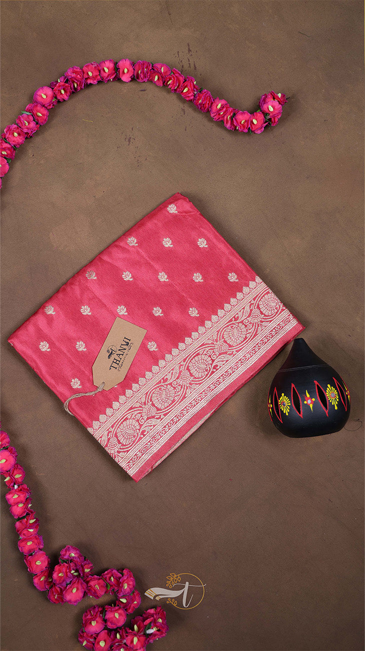 Pink saree with white border on a brown background