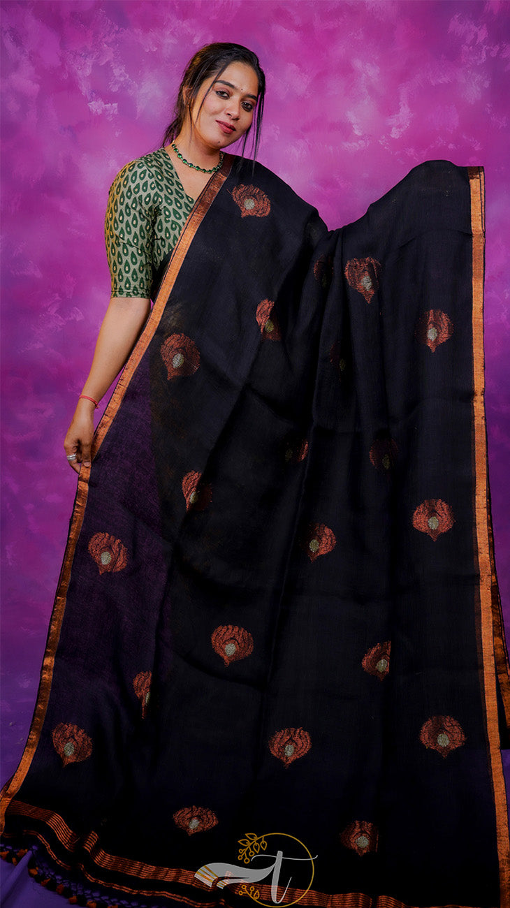 Woman wearing a black saree with gold patterns against a purple background