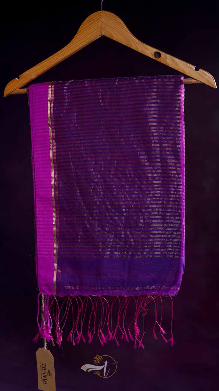Purple scarf with fringe on a wooden hanger against a dark background